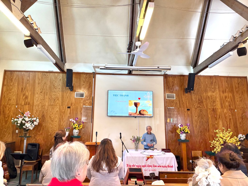 people in chuch sermon watching priest present slideshow